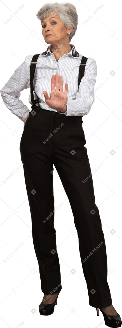 Front view of an old displeased female in office clothes showing a stop gesture