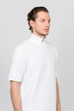 Young man in white polo t-shirt standing half-side to camera