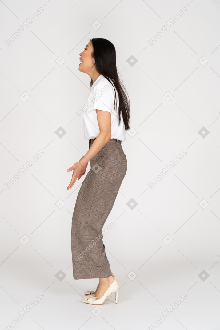 Seitenansicht einer springenden jungen dame in reithose und t-shirt, die kopf anheben