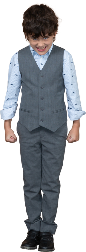 Vue de face d'un garçon en colère en costume gris debout avec les poings fermés