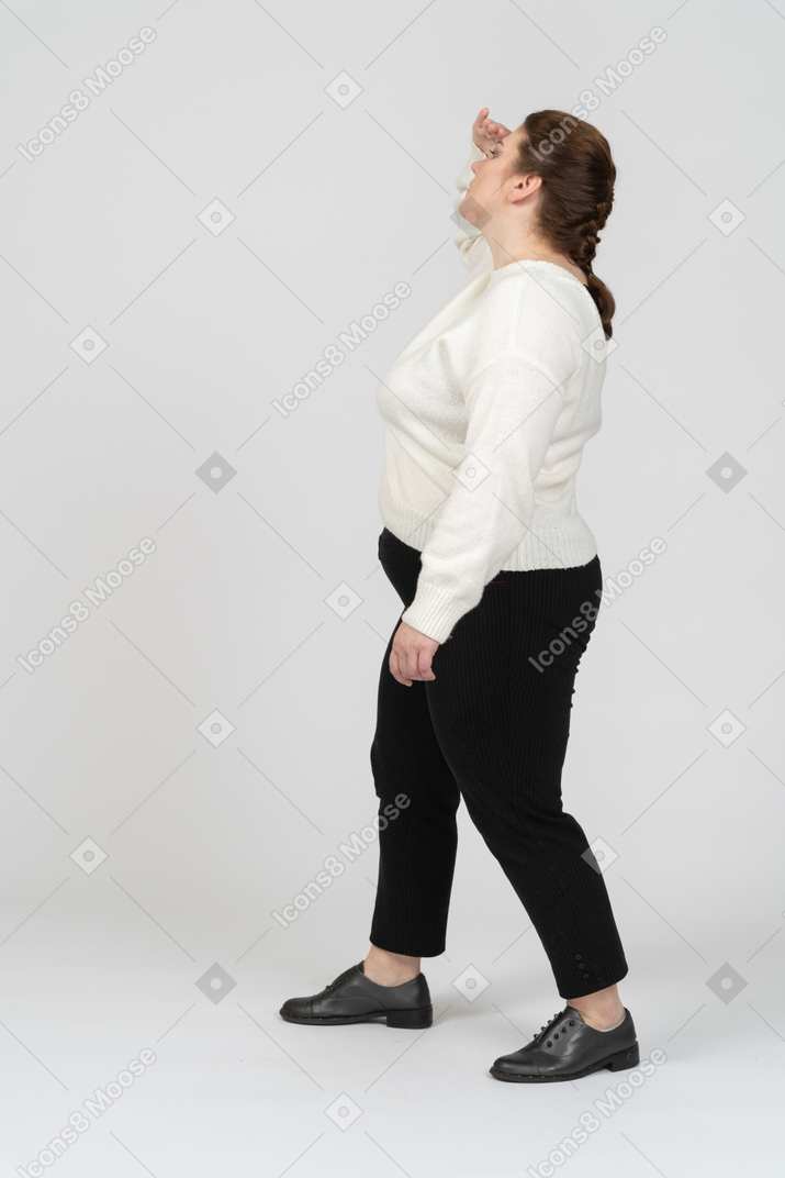 Vista laterale di una donna di taglie forti in abiti casual in cerca di qualcuno