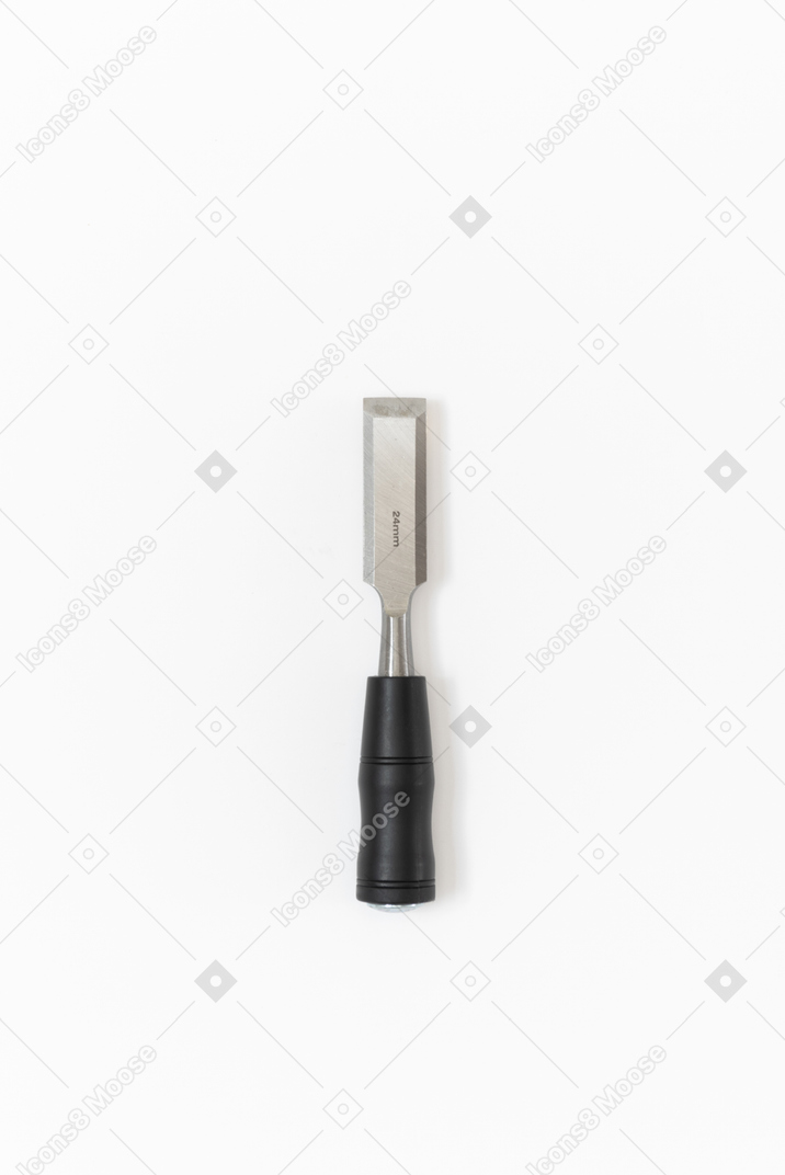 Uno scalpello di metallo con un manico nero disteso sul semplice sfondo bianco