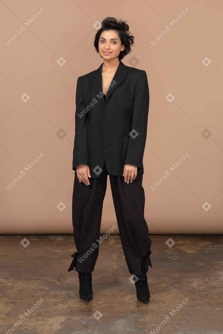 Vista frontal de una empresaria vistiendo traje negro y mirando a la cámara