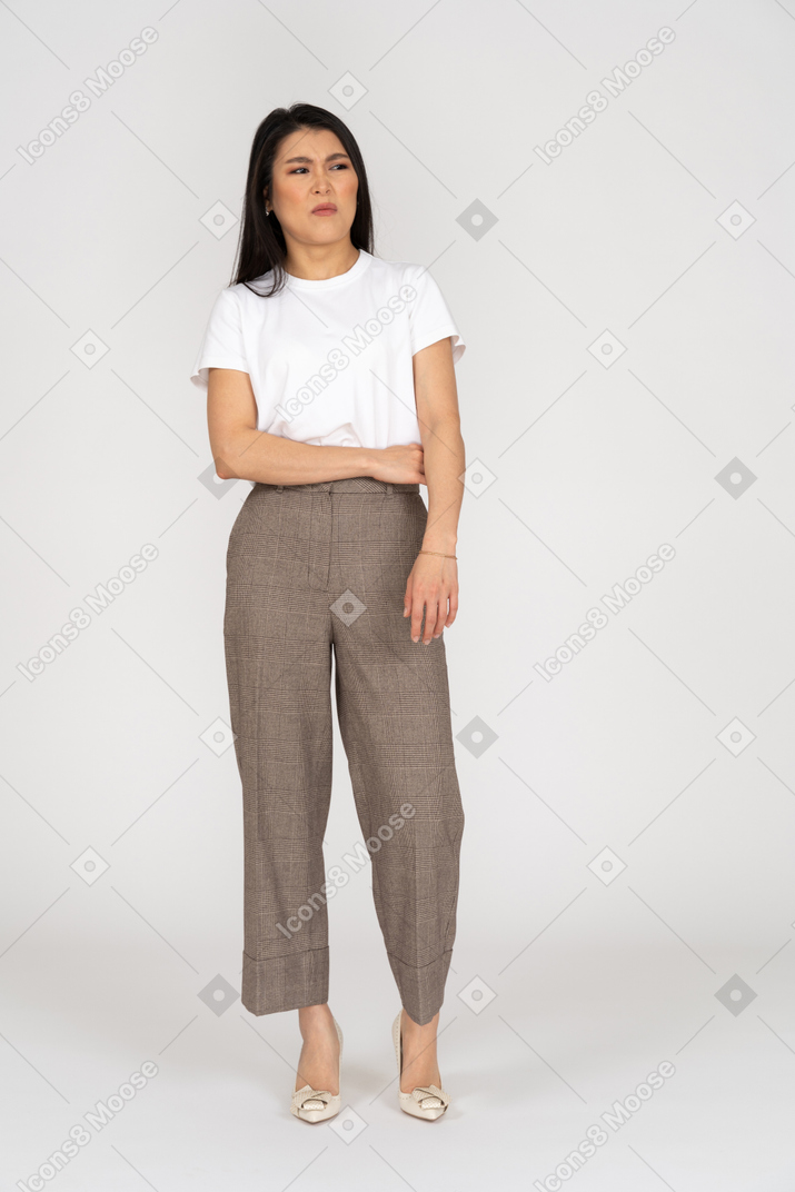 Front view of a displeased grimacing young lady in breeches and t-shirt