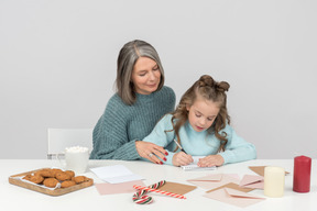 Abuela y nieta escribiendo una carta a santa juntos