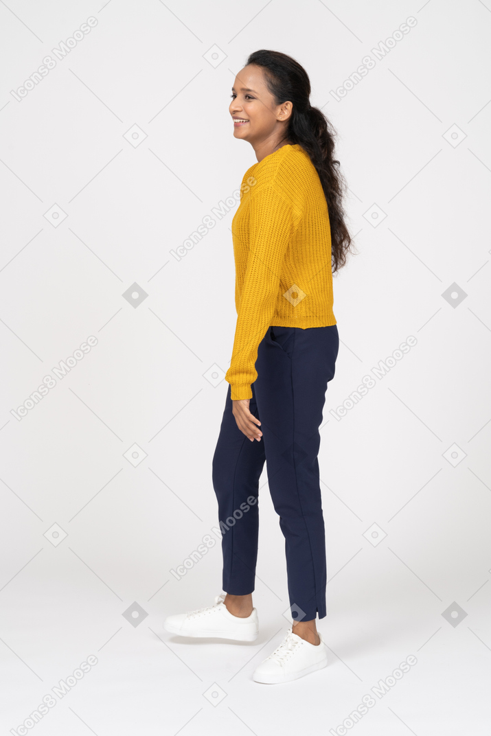 Happy girl in casual clothes standing in profile