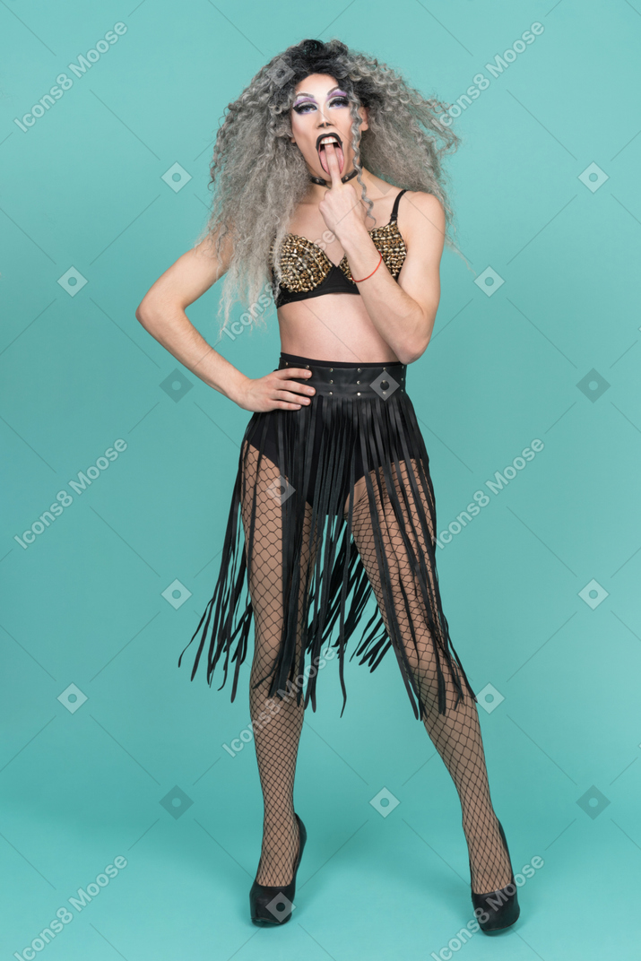 Drag queen in studded bra licking the middle finger