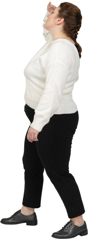 Side view of a plump woman in casual clothes looking for someone