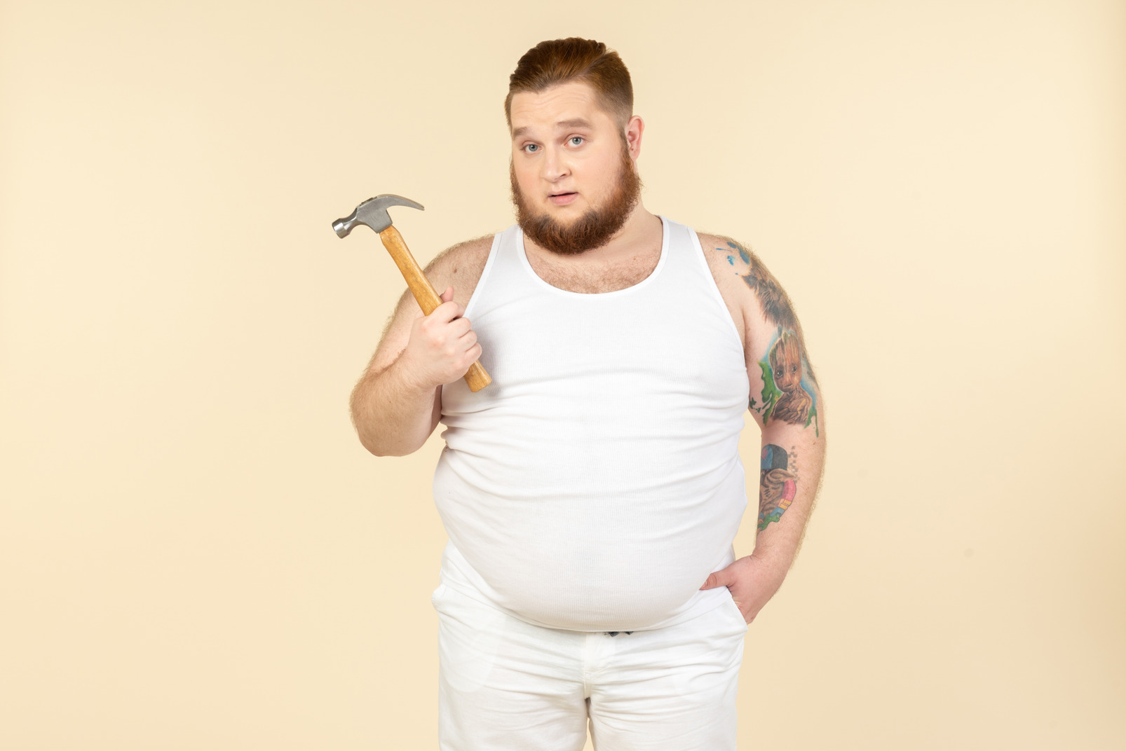Emotional young big guy holding hammer
