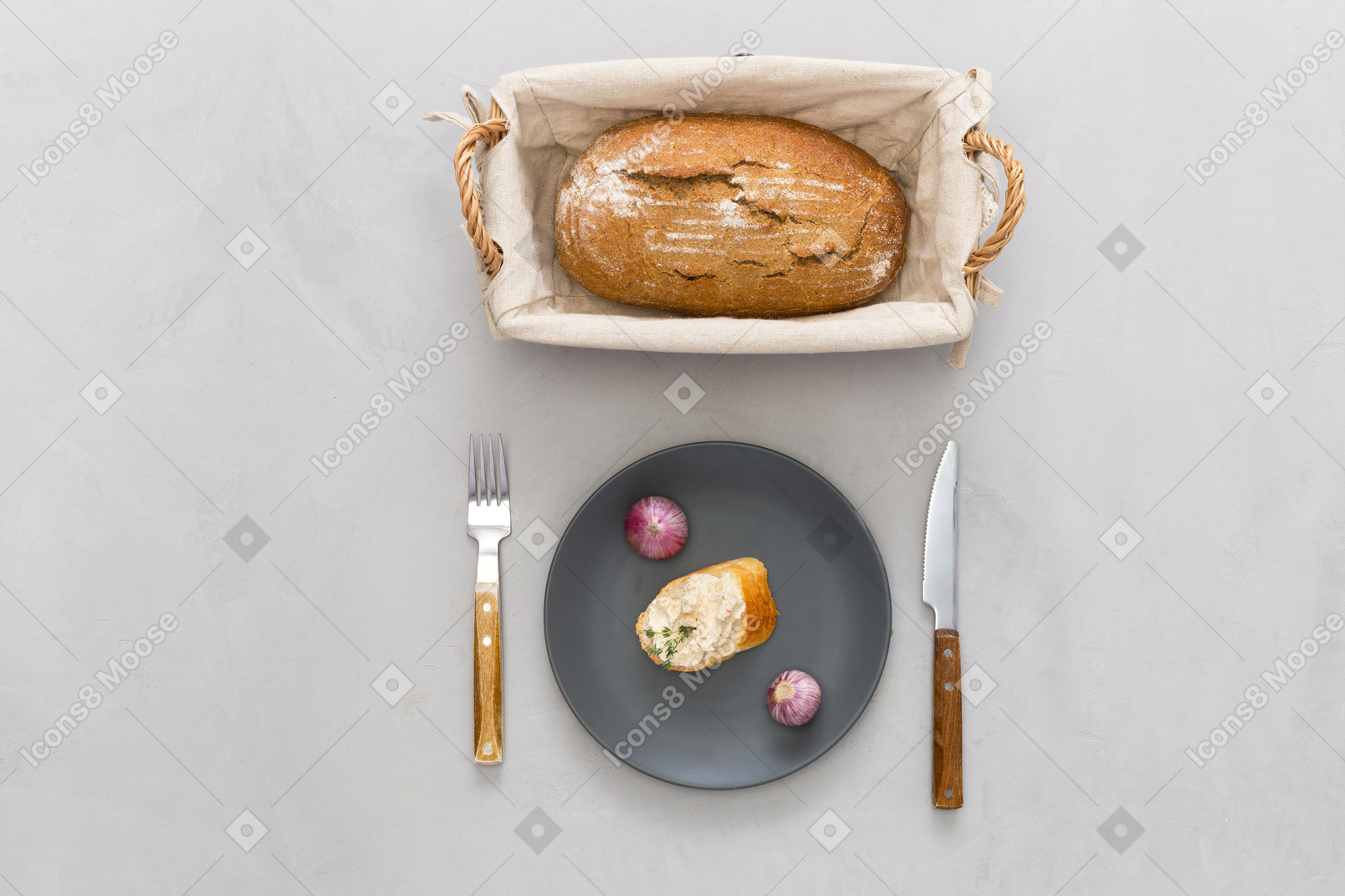 Кусок хлеба, столовые приборы и чесночный хлеб
