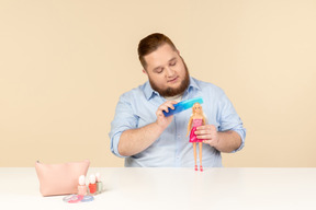 Big man holding hair brush and barbie doll