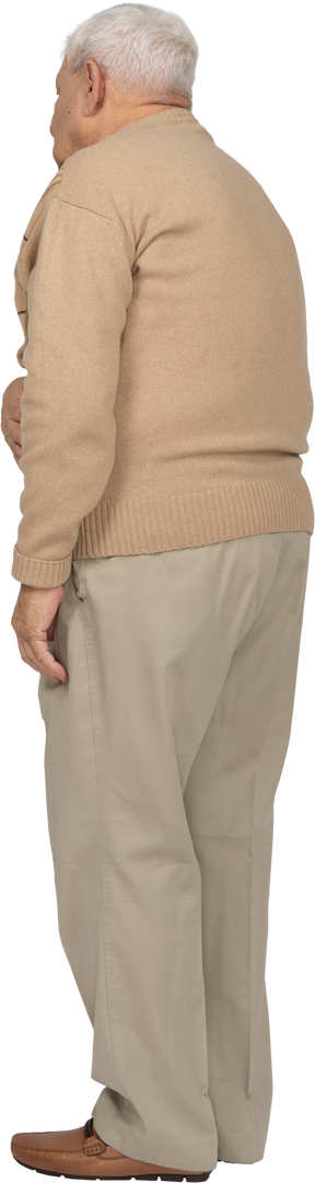 Vista lateral de un anciano con ropa informal que sufre de dolor de estómago