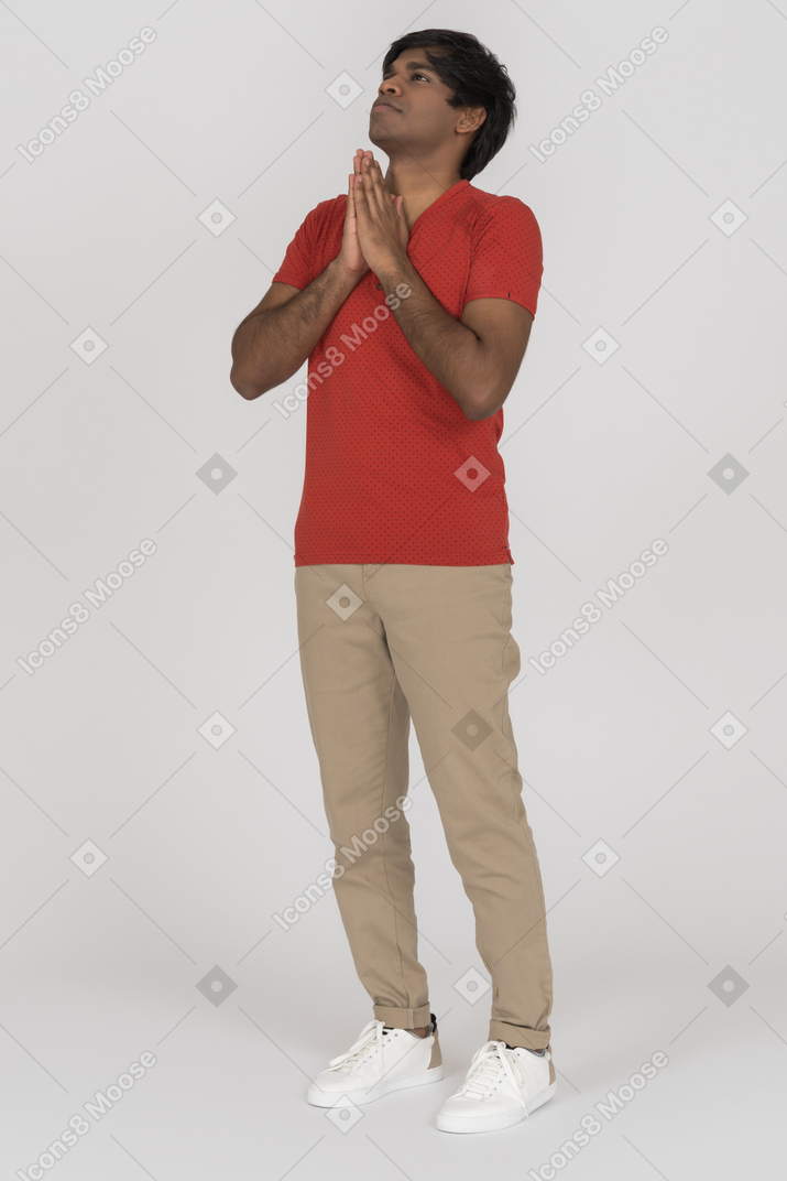 Young man looking up with praying hands