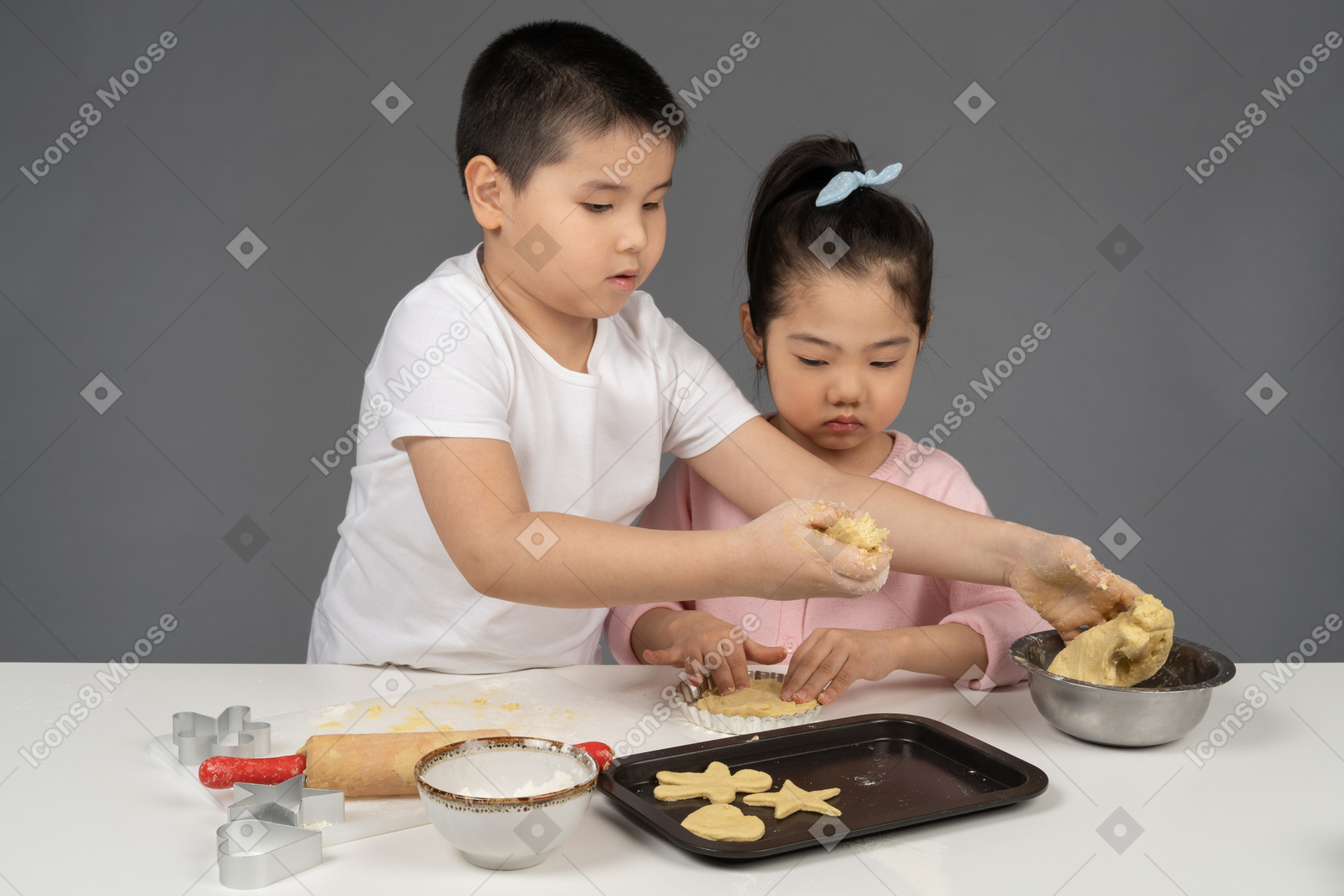 Boy teching his sister to bake cookies