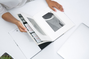 Mains féminines tenant un album photo ouvert en noir et blanc