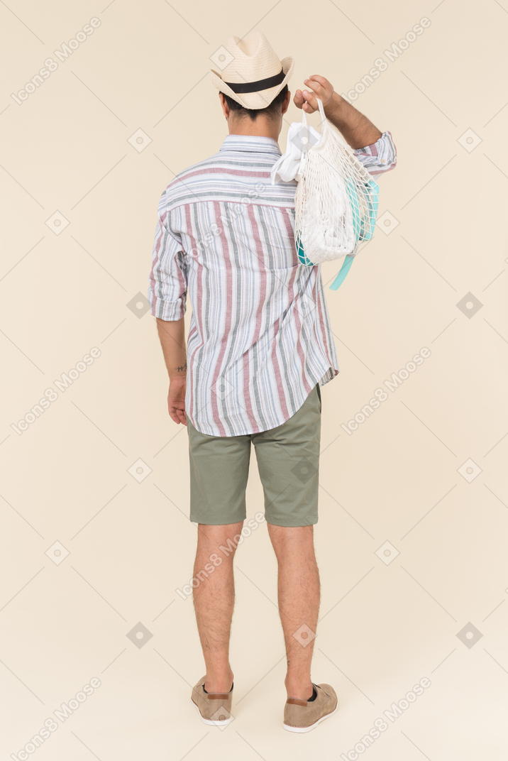 Homme tenant avoska sur son épaule et debout devant la caméra