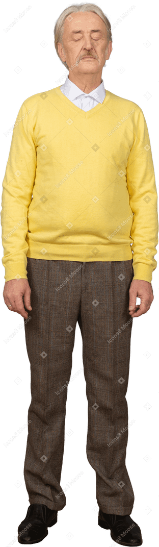 Front view of an old man wearing yellow pullover and standing still with his eyes closed