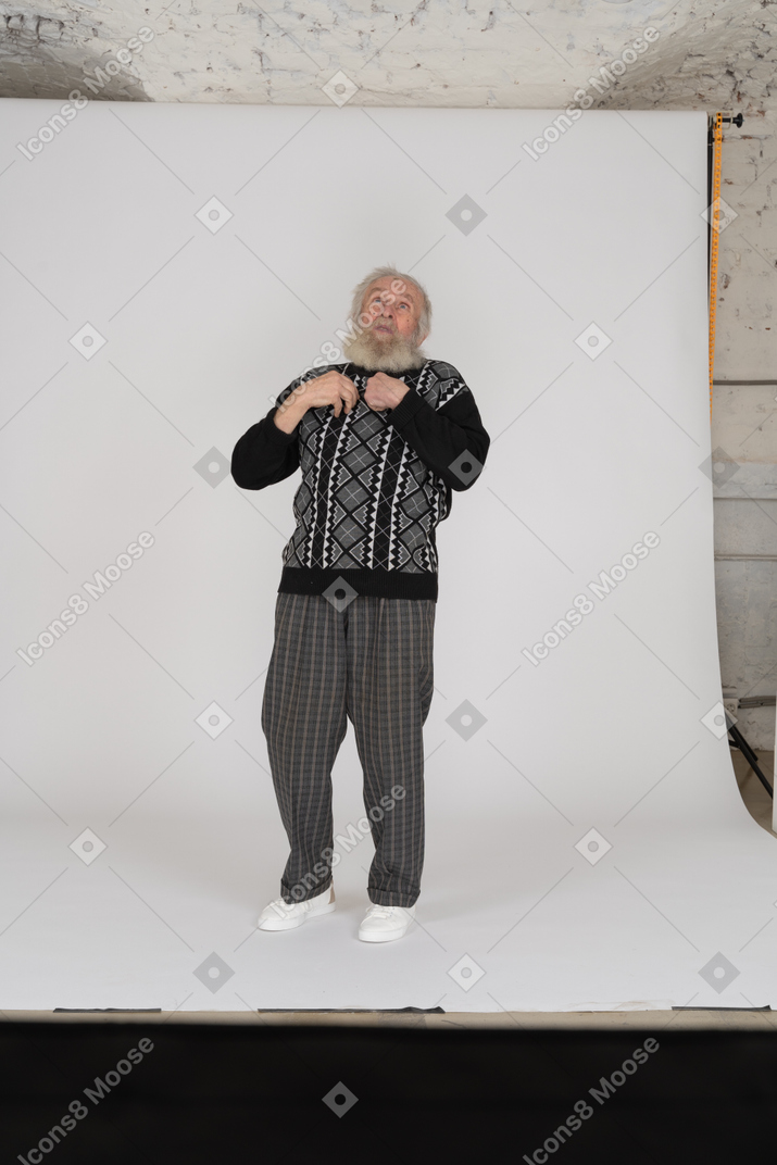 Old man looking up with arms at chest
