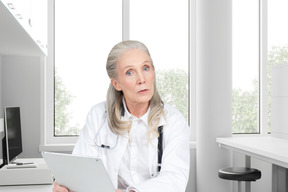 A doctor holding a tablet in her office