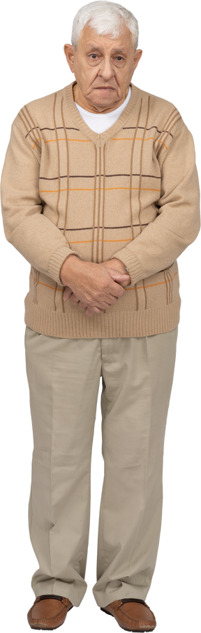 Front view of a sad old man in casual clothes looking at camera
