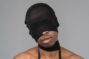 Young man being blindfolded and choked with black tights