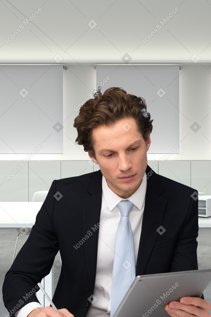 A man in a suit sitting at a table with a tablet