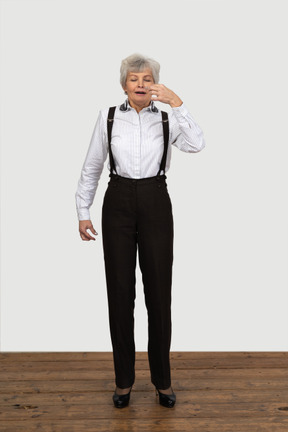 Vista frontal de una anciana en ropa de oficina estornudos en interiores