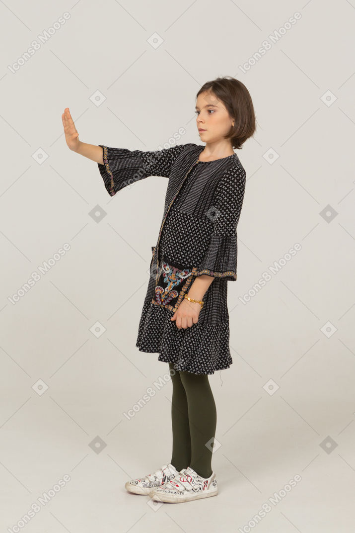 一个穿着裙子的小女孩伸出手的四分之三视图