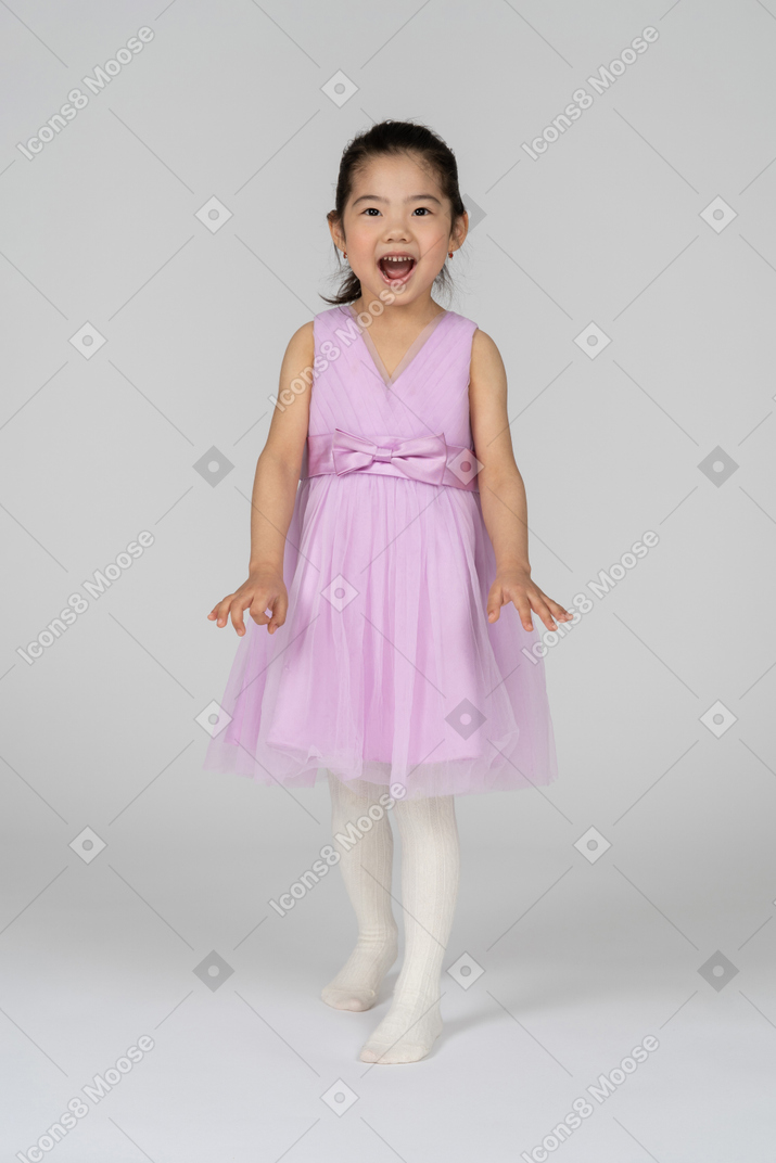 Petite fille dans une robe tutu posant de manière ludique