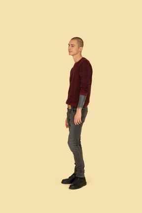 じっと立っている赤いプルオーバーの若い男の正面図
