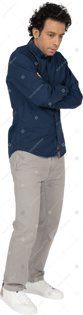 Vista frontale di un uomo in abiti casual in posa con le braccia incrociate
