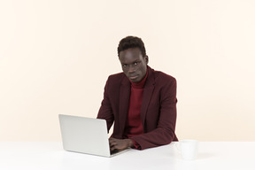 Élégant homme noir assis à la table dans le bureau