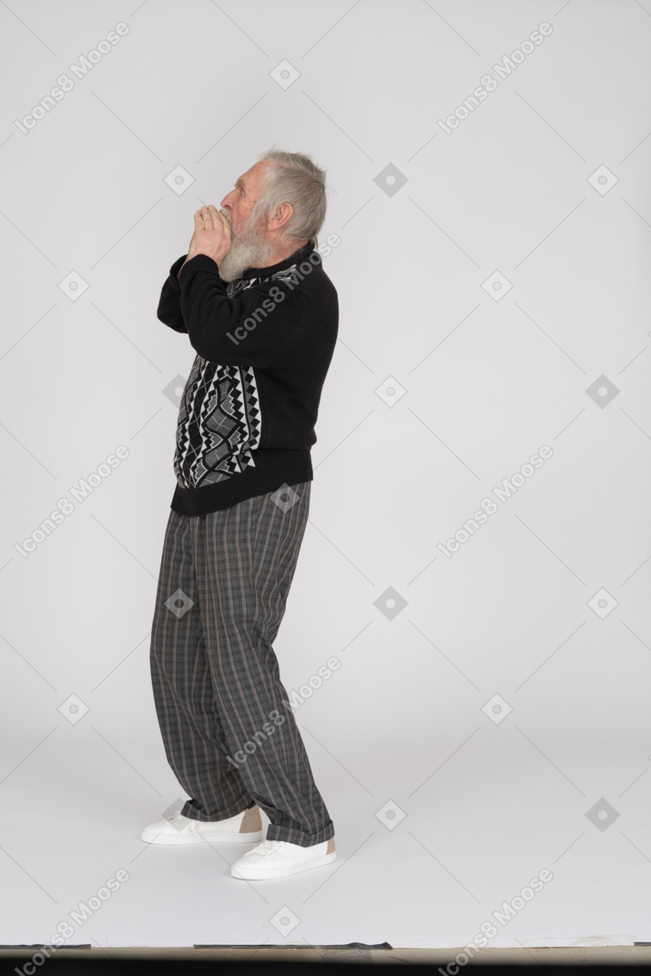 Side view of senior man shouting with hands cupped around his mouth