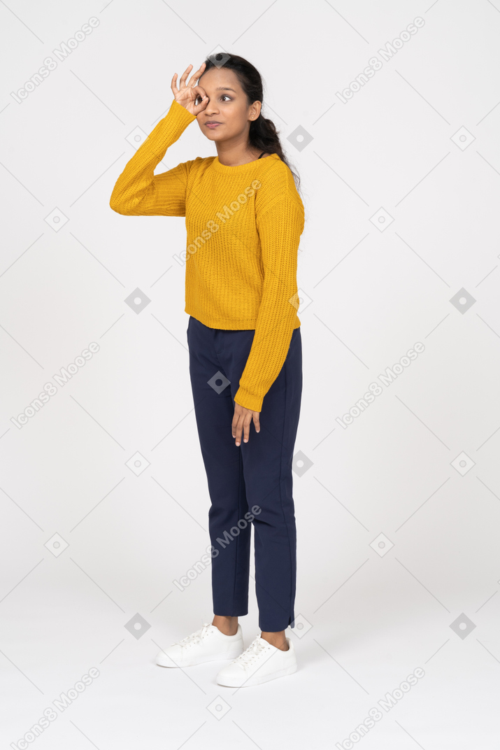 Front view of a girl in casual clothes looking through fingers