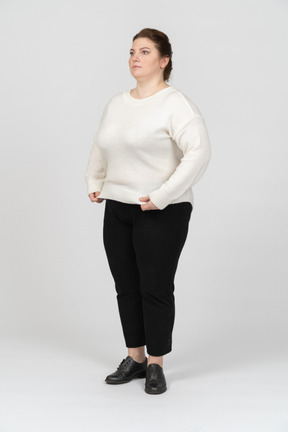 Vista laterale di una donna grassoccia in abiti casual in piedi