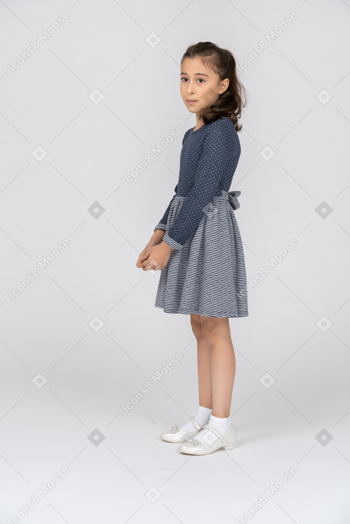 Side view of a girl clasping hands in front of her
