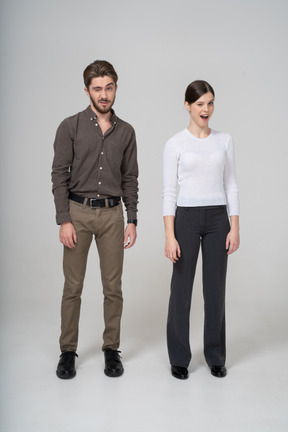 Front view of a winking young couple in office clothing