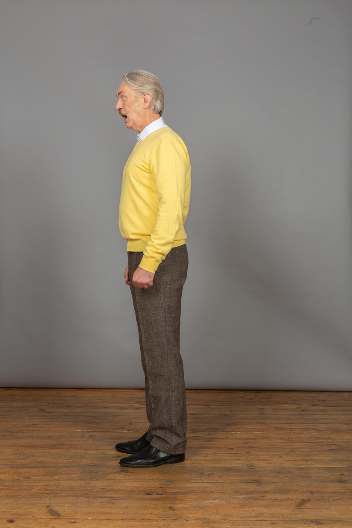 Side view of a talking man in a yellow pullover