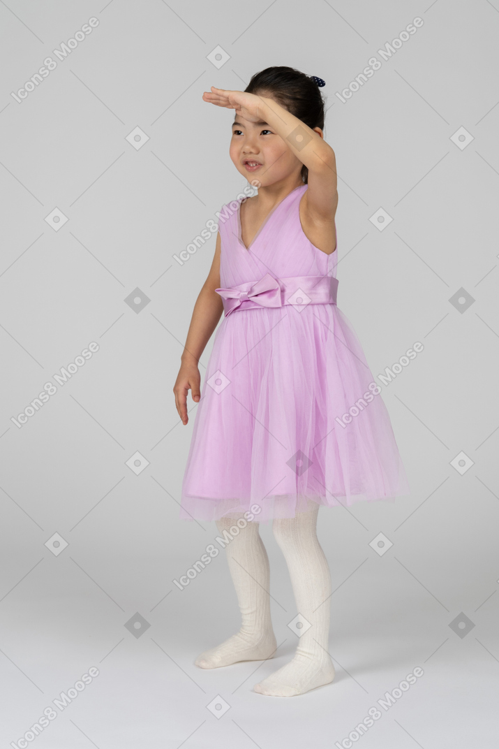 穿着粉红色连衣裙的小女孩望向别处