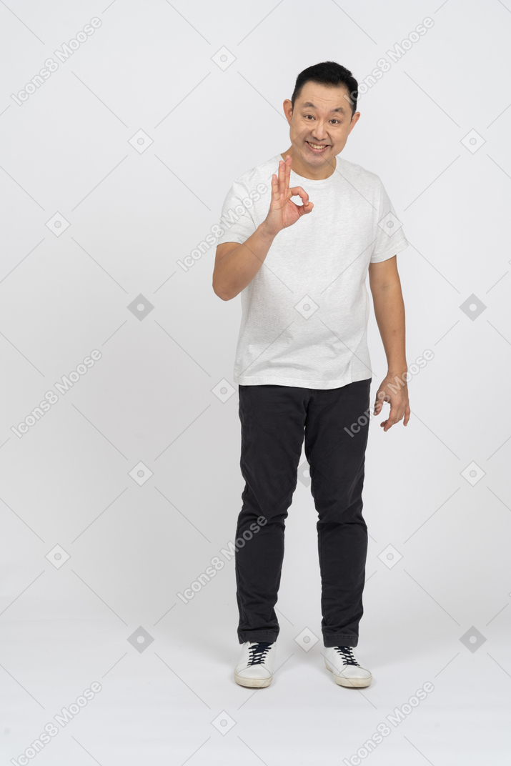 Front view of a happy man in casual clothes showing ok sign