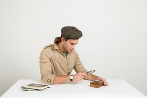 Handsome young investigator looking on wooden box through magnifying glass