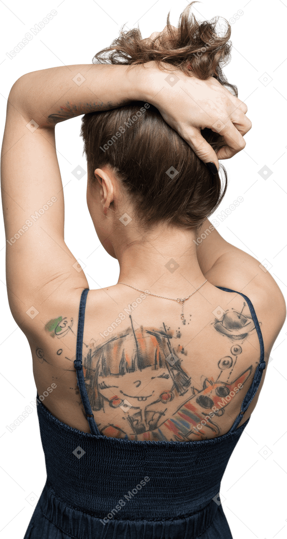 Mulher em pé de costas para a câmera e levantando o cabelo para mostrar as costas tatuadas