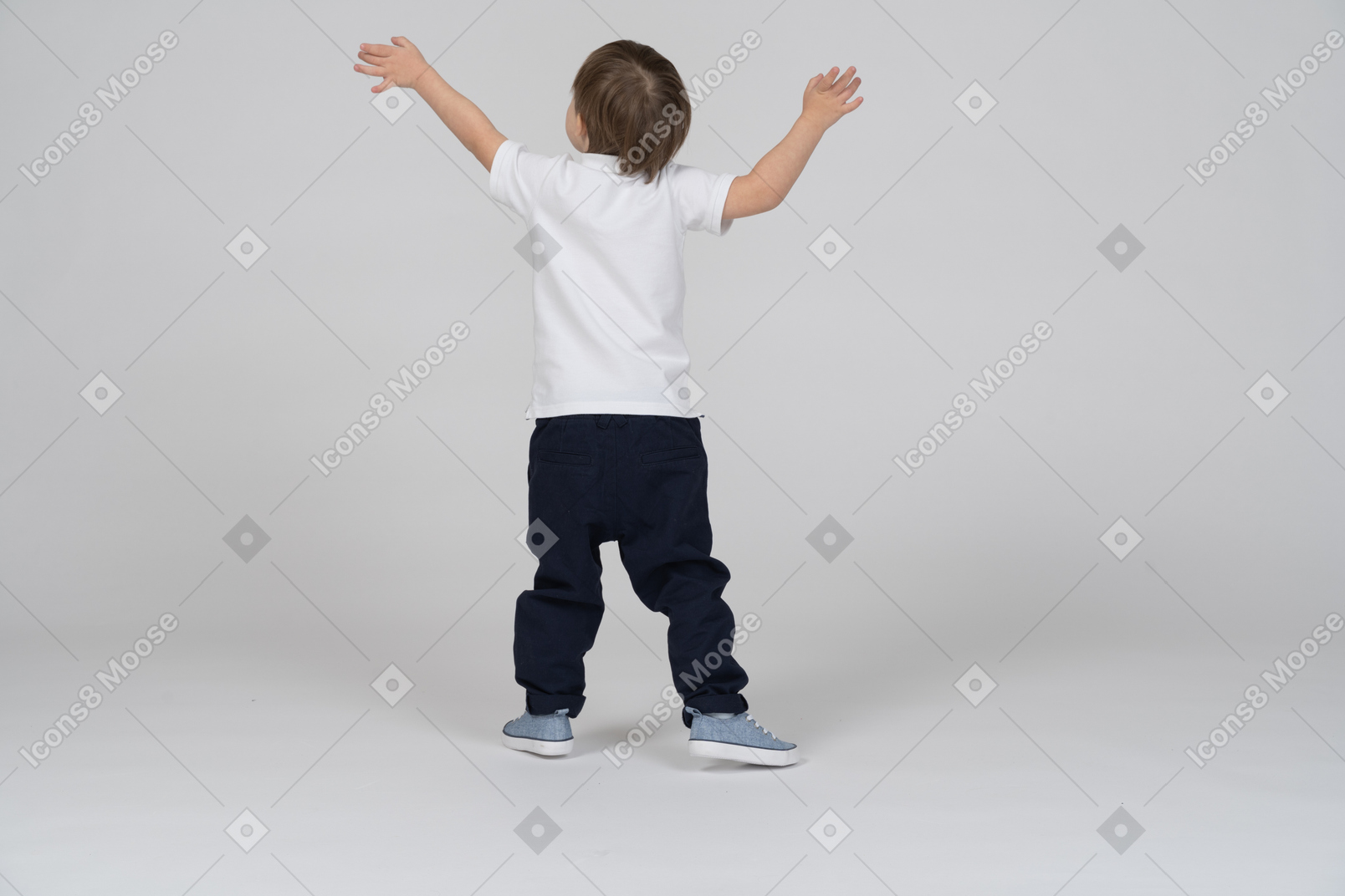 Back view of a little boy standing with his arms raised