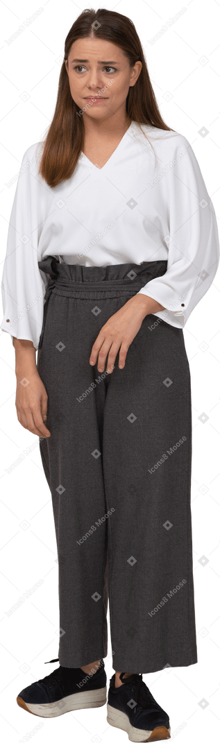 Front view of an upset young lady in office clothing looking aside