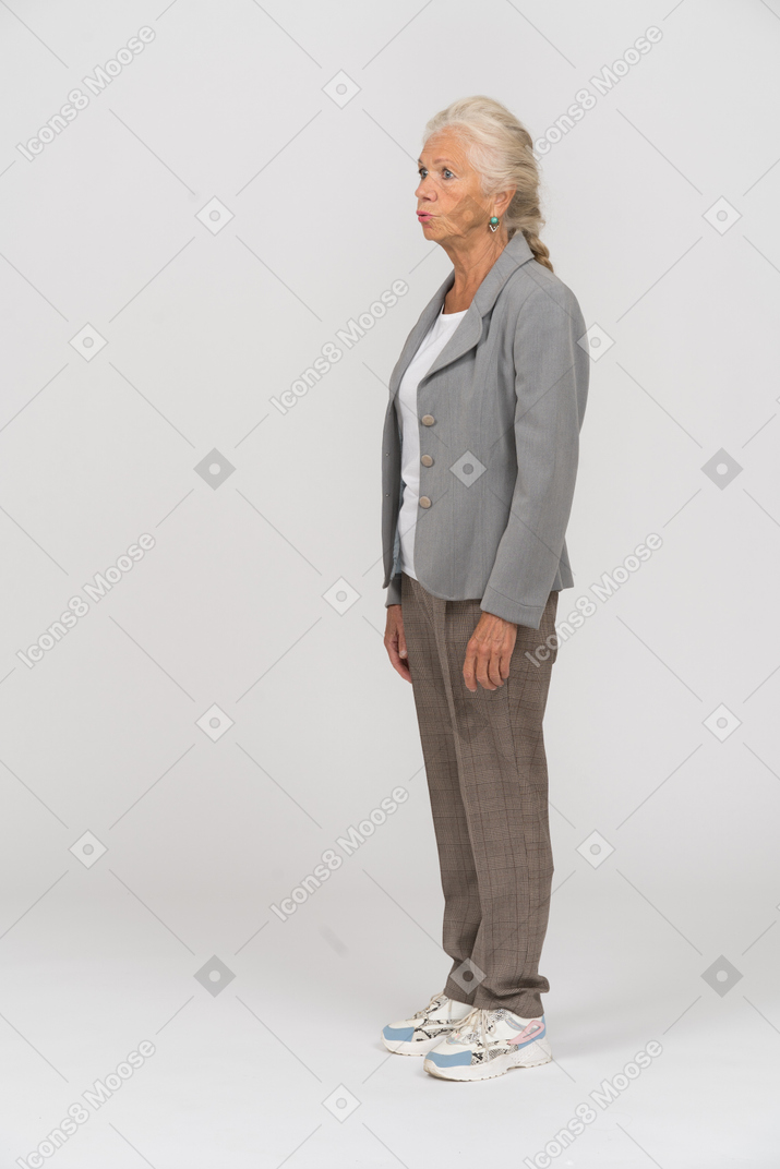 Vista laterale di una vecchia donna in giacca grigia che fa le smorfie