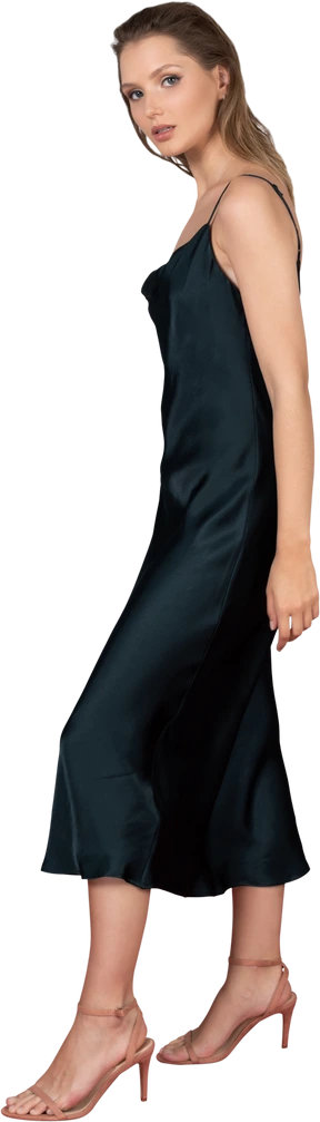 Side view of a young woman in night gown posing on a red carpet