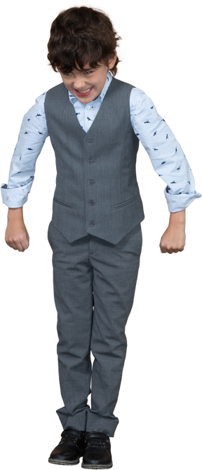 Vista frontal de um menino zangado em um terno cinza em pé com os punhos cerrados