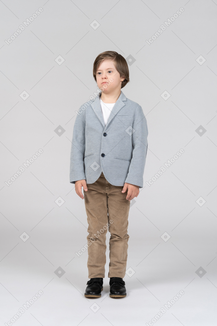 A young boy in a gray jacket and khaki pants