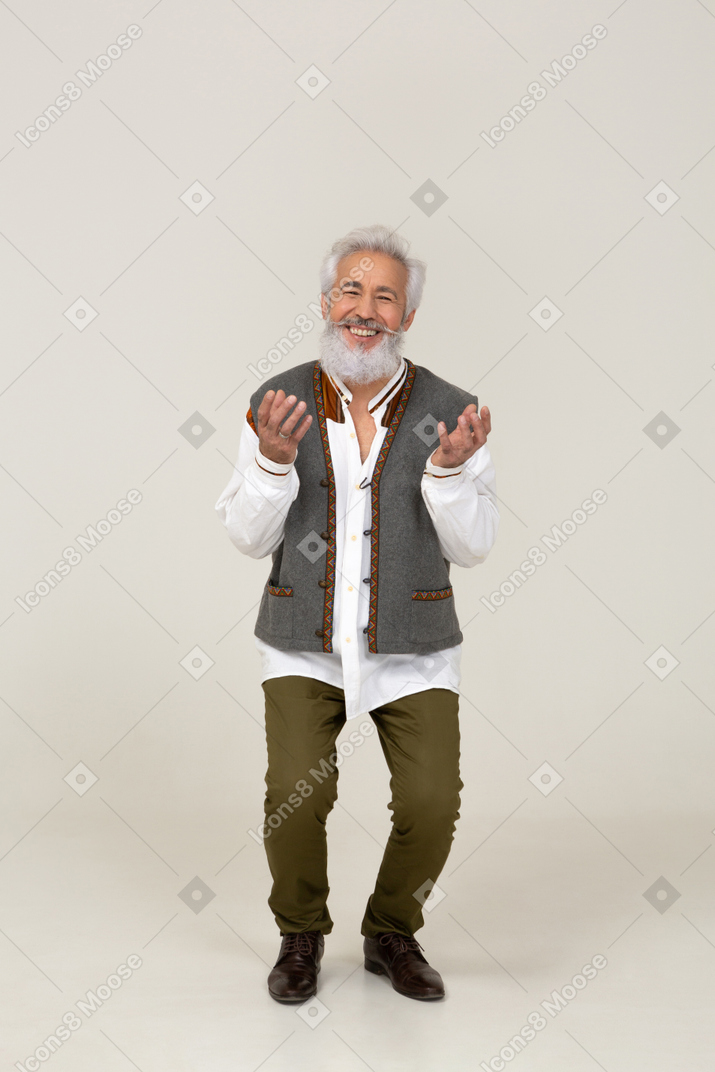 Homem feliz em pé com os joelhos dobrados e as palmas das mãos viradas para cima
