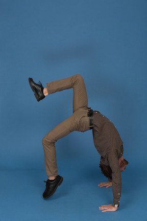 Slim young man doing gymnastic exercises